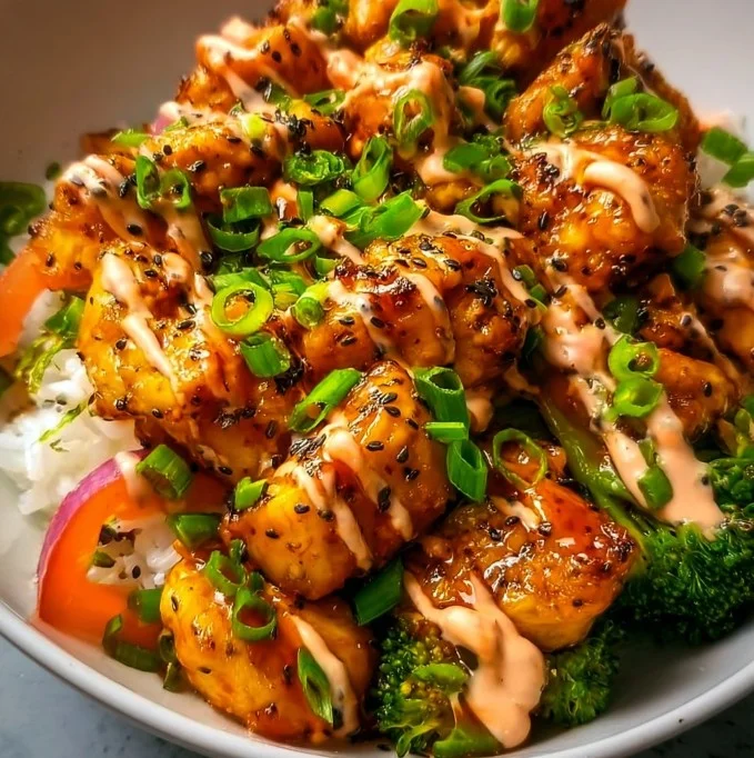 Delicious Bang Bang Chicken Bowl garnished with fresh vegetables and herbs