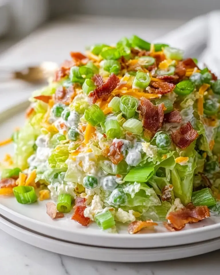 A colorful 7 layer salad with vibrant vegetables and toppings in a glass dish.